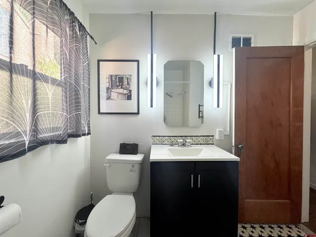 a bathroom with a toilet sink and mirror