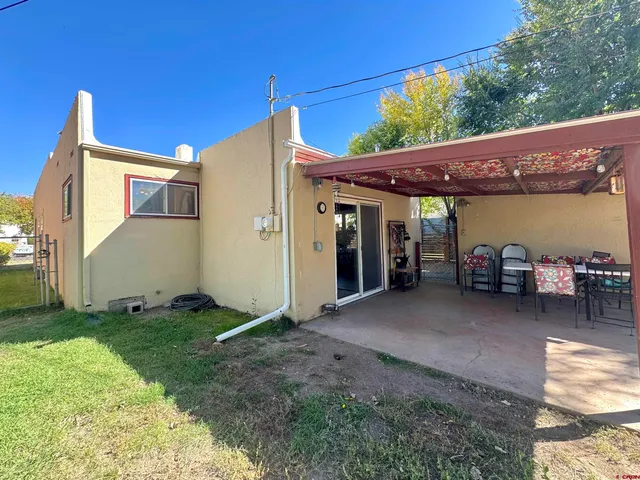 a view of a patio with table and chairs and a barbeque