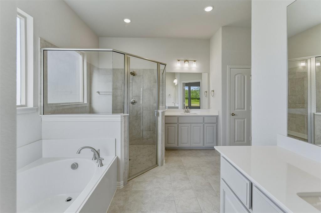 605 Tay Tay Way Springtown, TX 76082 - Photo 21 of 31 Spacious bathroom featuring a built-in bathtub with chrome fixtures, a glass-enclosed shower, dual vanity with light gray cabinetry and white countertops, and recessed lighting