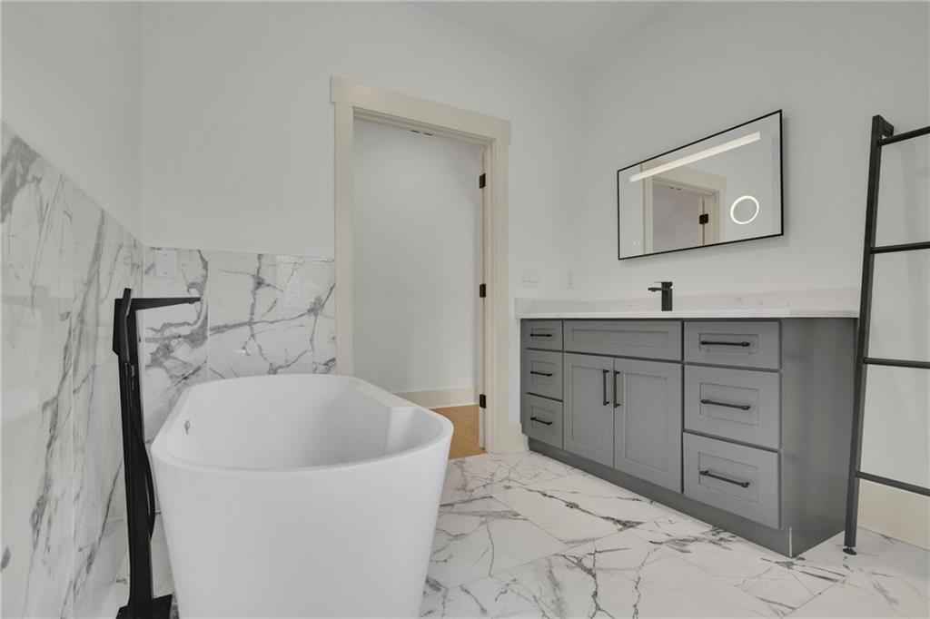 5525 Hubbard Town Road Cumming, GA 30028 - Photo 54 of 84 a bathroom with a tub sink and mirror