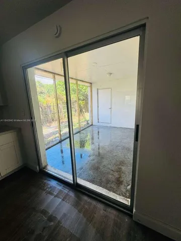 an empty room with wooden floor and door