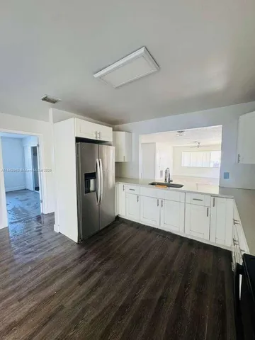 a view of a kitchen with wooden floor and electronic appliances
