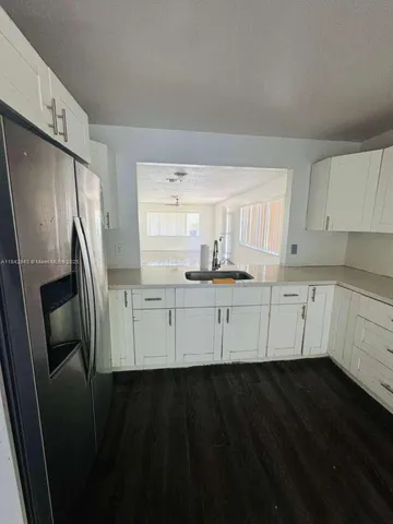 a kitchen with cabinets and a refrigerator