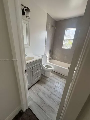 a bathroom with a sink a toilet a mirror and shower