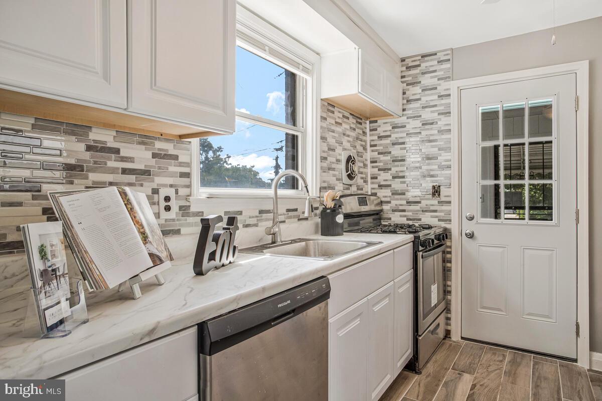 617 Annabel Avenue Baltimore, MD 21225 - Photo 16 of 40 a kitchen with a sink a stove and cabinets