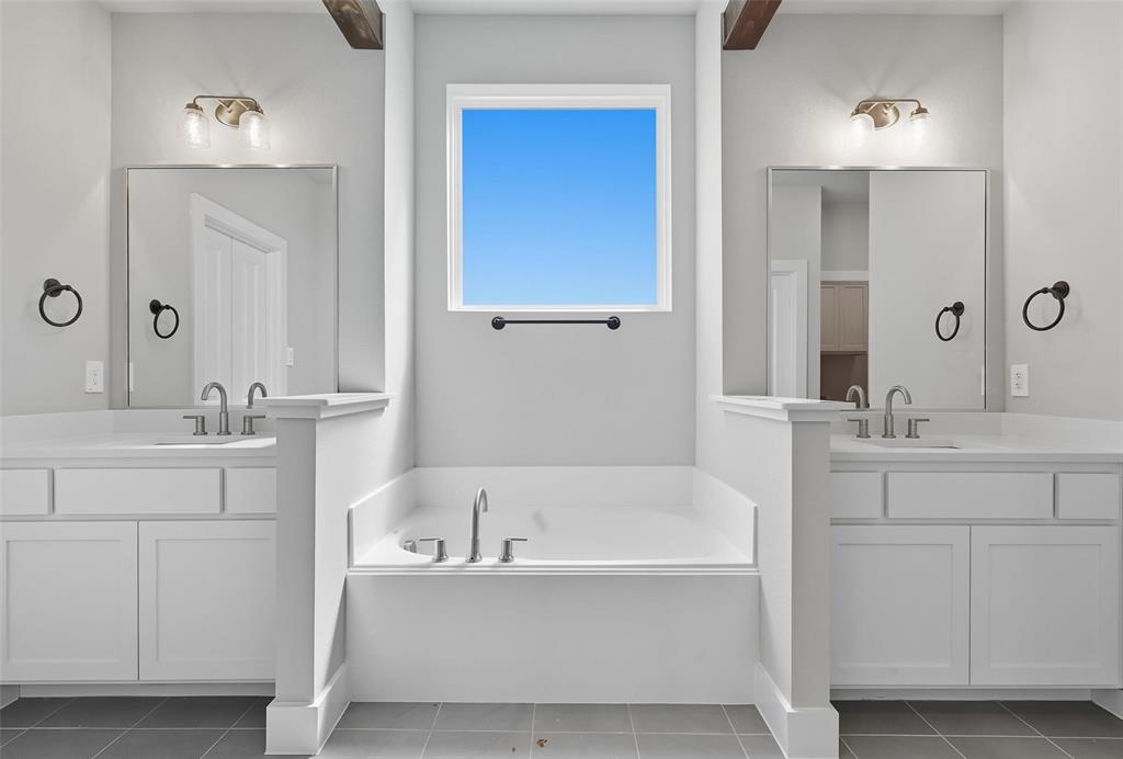 1005 Ronnie Court Springtown, TX 76082 - Photo 17 of 27 Full bath featuring a garden tub, two vanities, and dark tile patterned floors
