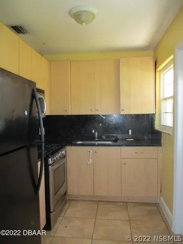 a kitchen with granite countertop a sink a stove and a refrigerator