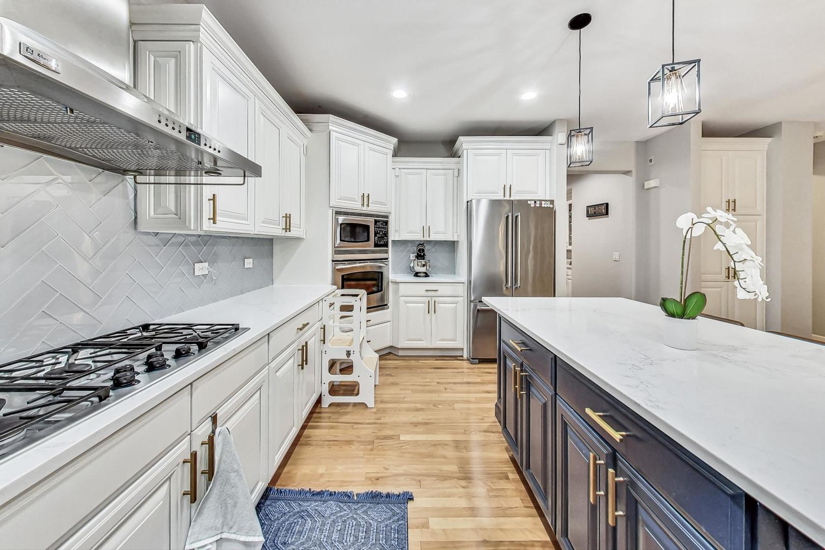 2680 Summit Drive Glenview, IL 60025 - Photo 15 of 70 a kitchen with kitchen island white cabinets stainless steel appliances and a center island