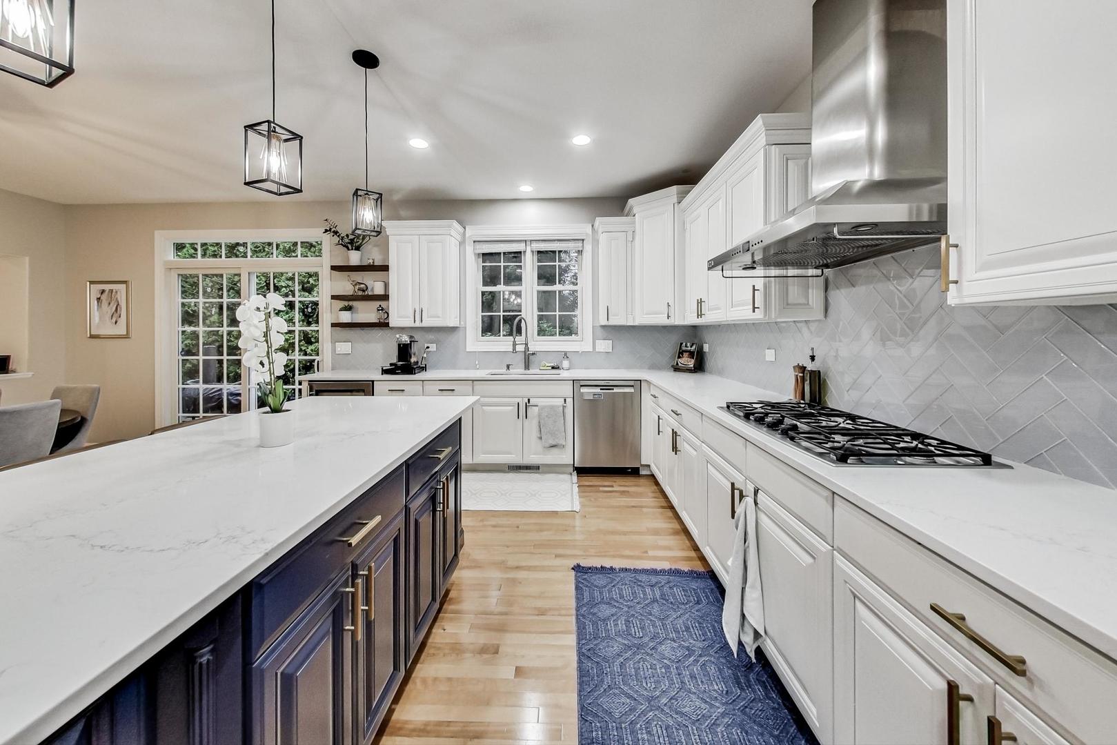 2680 Summit Drive Glenview, IL 60025 - Photo 16 of 70 a kitchen with kitchen island a stove a sink a counter space and wooden floor