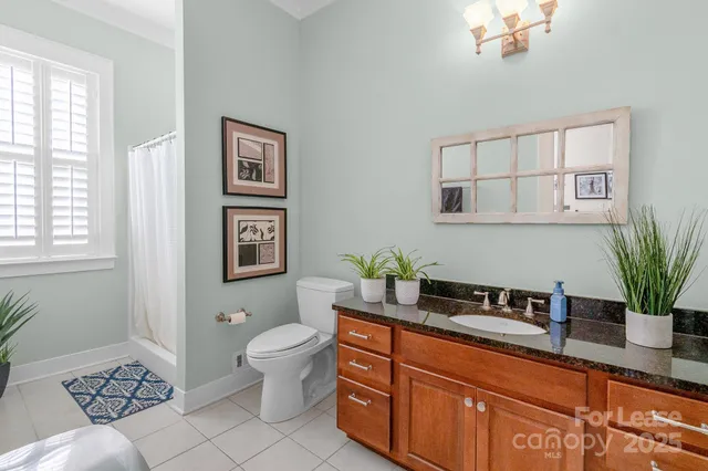 a bath room with a toilet a sink and a mirror
