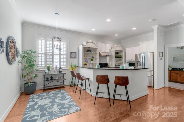 a living room with stainless steel appliances kitchen island granite countertop furniture and a wooden floor
