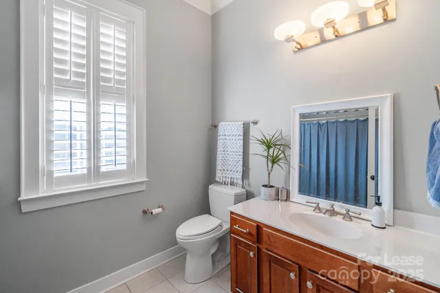 a bathroom with a granite countertop sink a mirror and a toilet