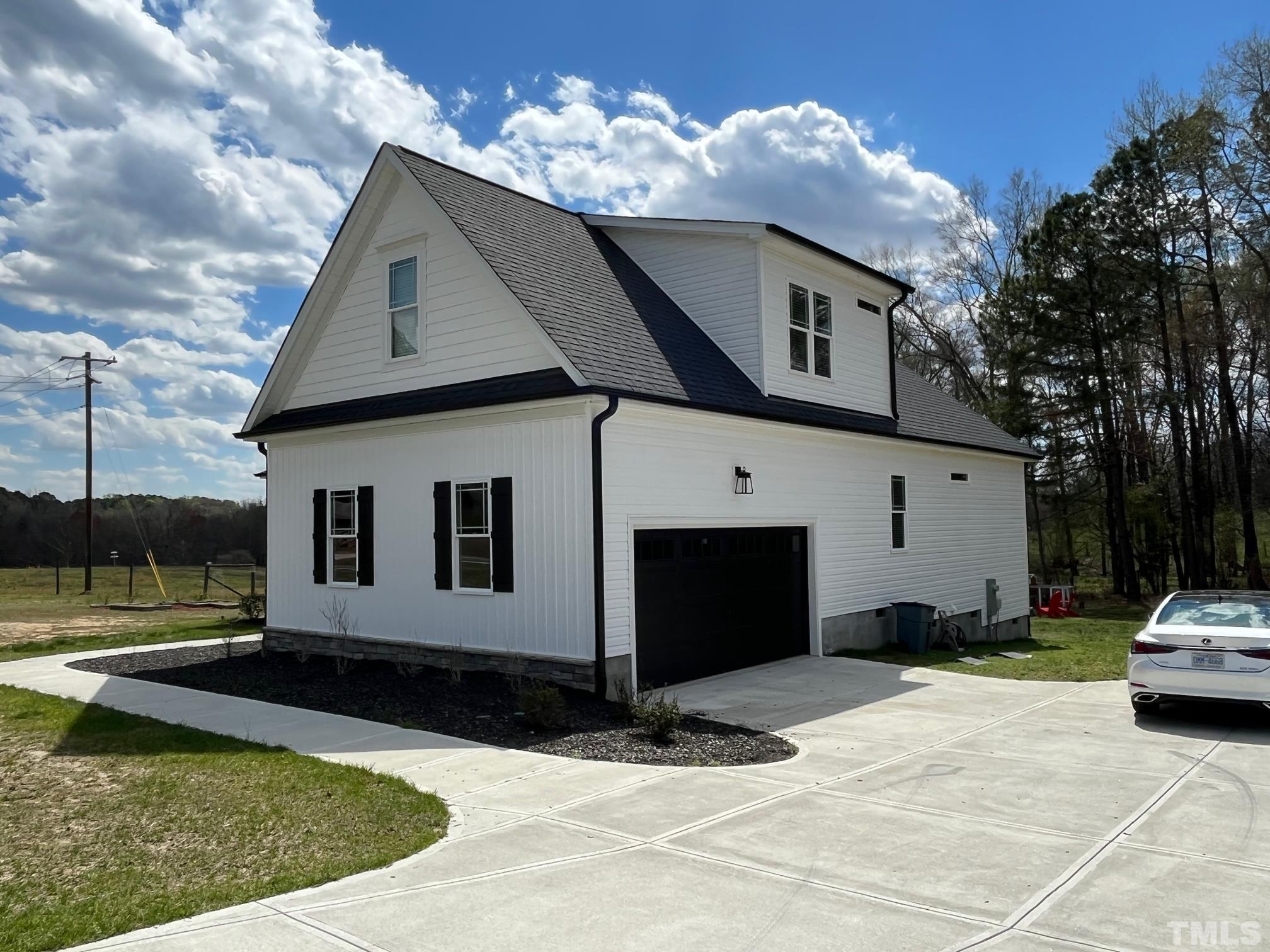 189 Brantleytown Road Zebulon, NC 27597 - Photo 3 of 46 a view of a white house with large windows and a yard