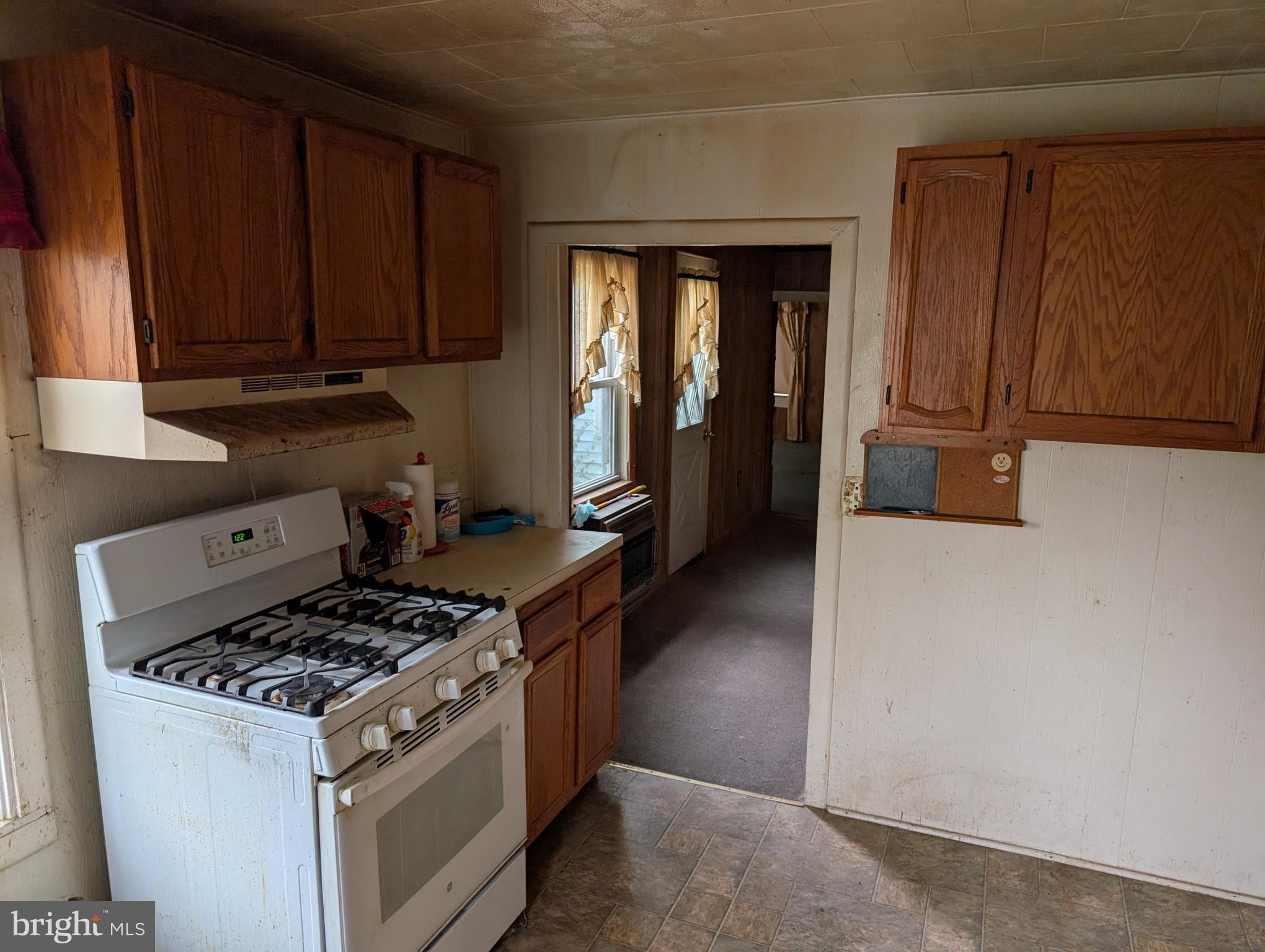 6 West State Street Delmar, MD 21875 - Photo 3 of 10 a kitchen with wooden cabinets and a stove top oven