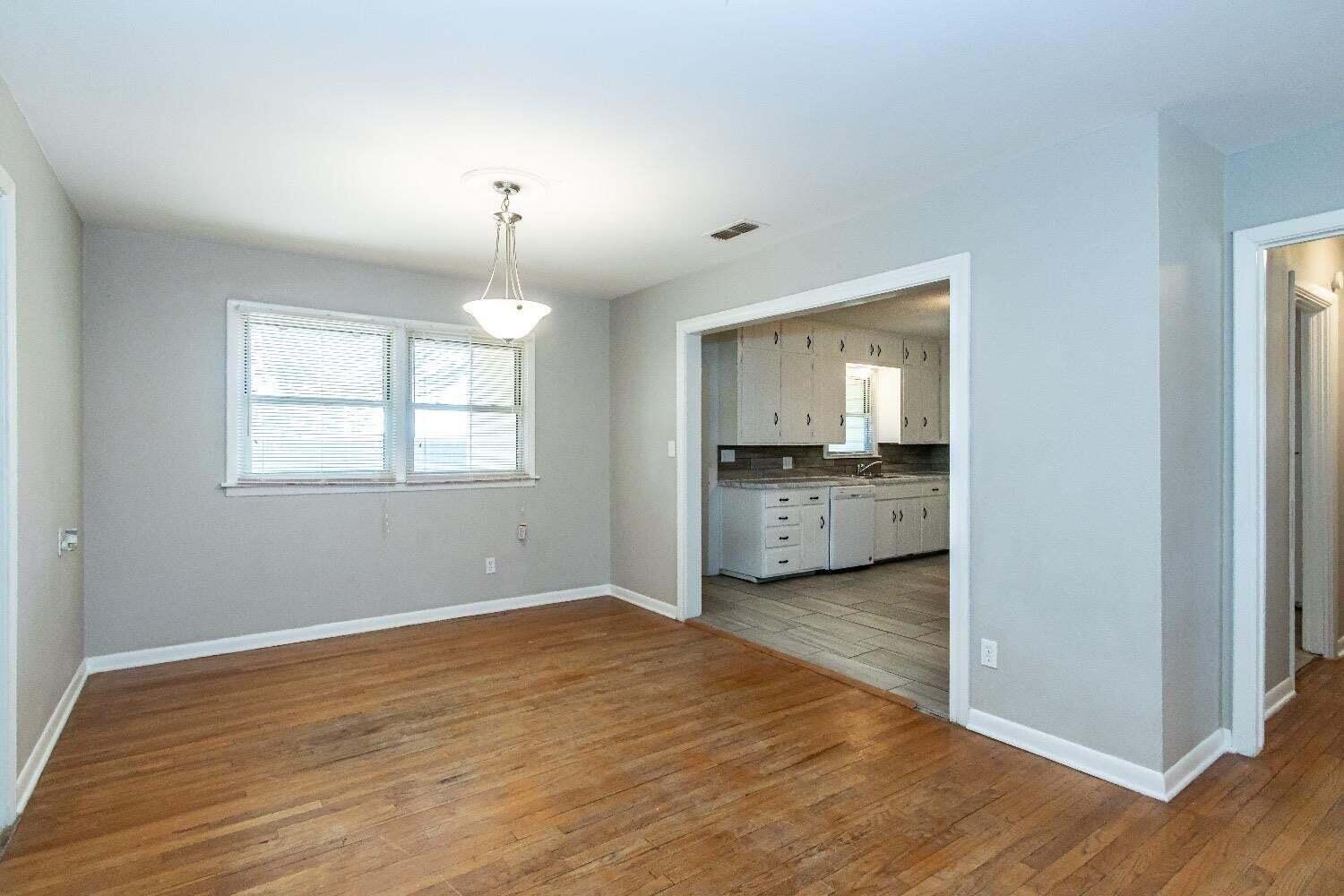 4212 42nd Street Lubbock, TX 79413 - Photo 5 of 18 a view of an empty room with a window and wooden floor