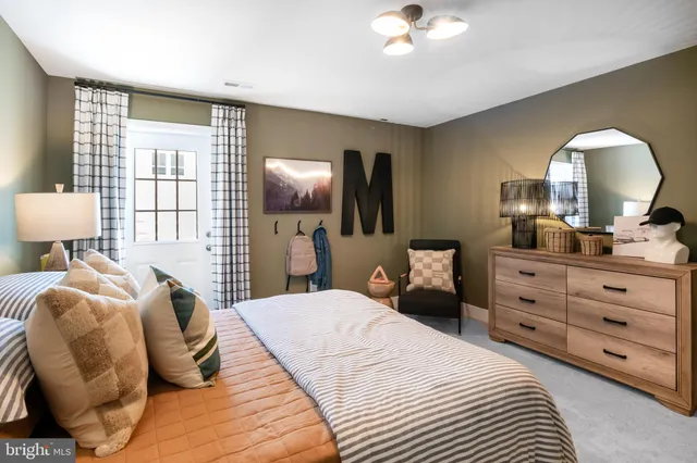 a bedroom with a bed and a large mirror on the dresser