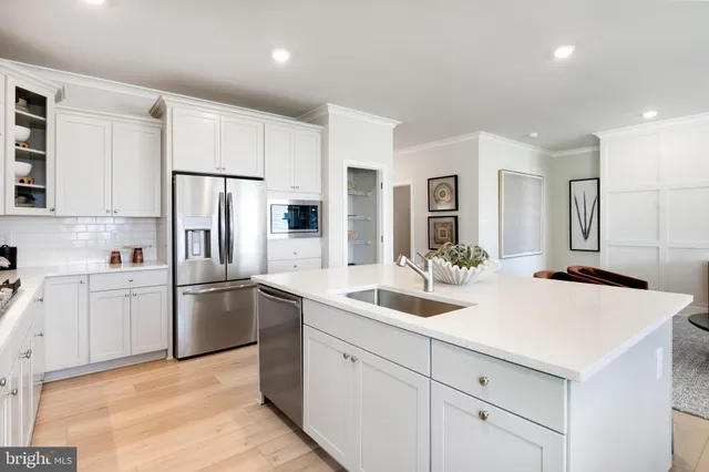 a kitchen with white cabinets and refrigerator