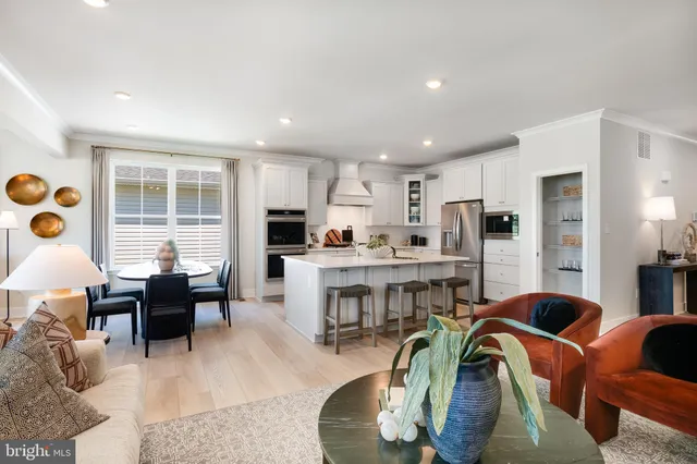 a living room with stainless steel appliances furniture and a large window