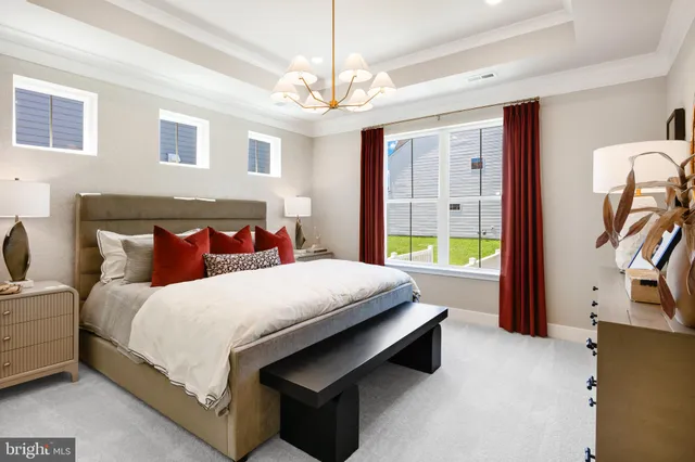 a bedroom with a large bed and a chandelier