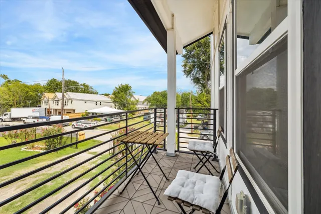a view of a balcony with chairs and wooden floor