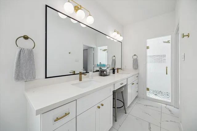 a spacious bathroom with a double vanity sink mirror and shower