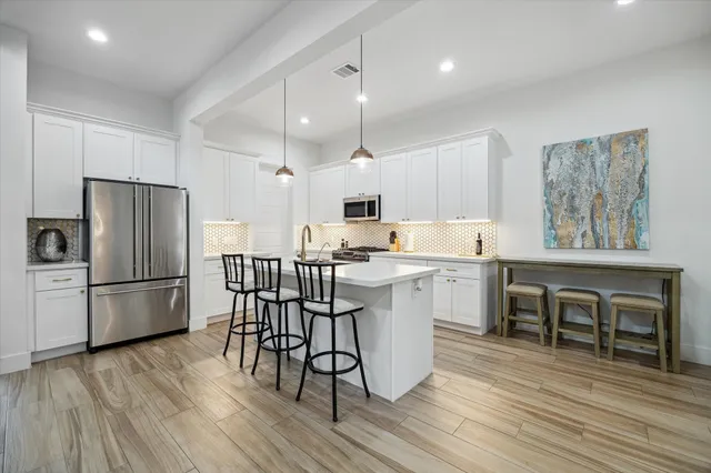 a kitchen with a refrigerator a dining table and chairs