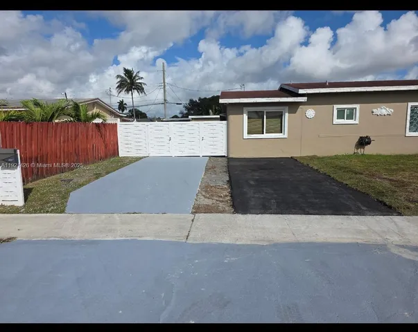 a view of a house with backyard and tree