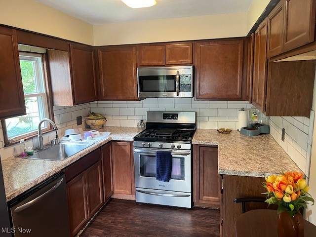 1590 Lillian Road Stow, OH 44224 - Photo 9 of 12 Kitchen featuring tasteful backsplash, dark hardwood / wood-style floors, stainless steel appliances, and sink