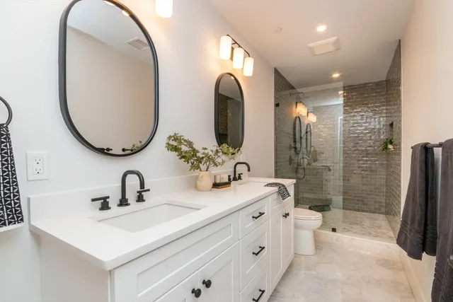 a bathroom with a double vanity sink mirror and shower