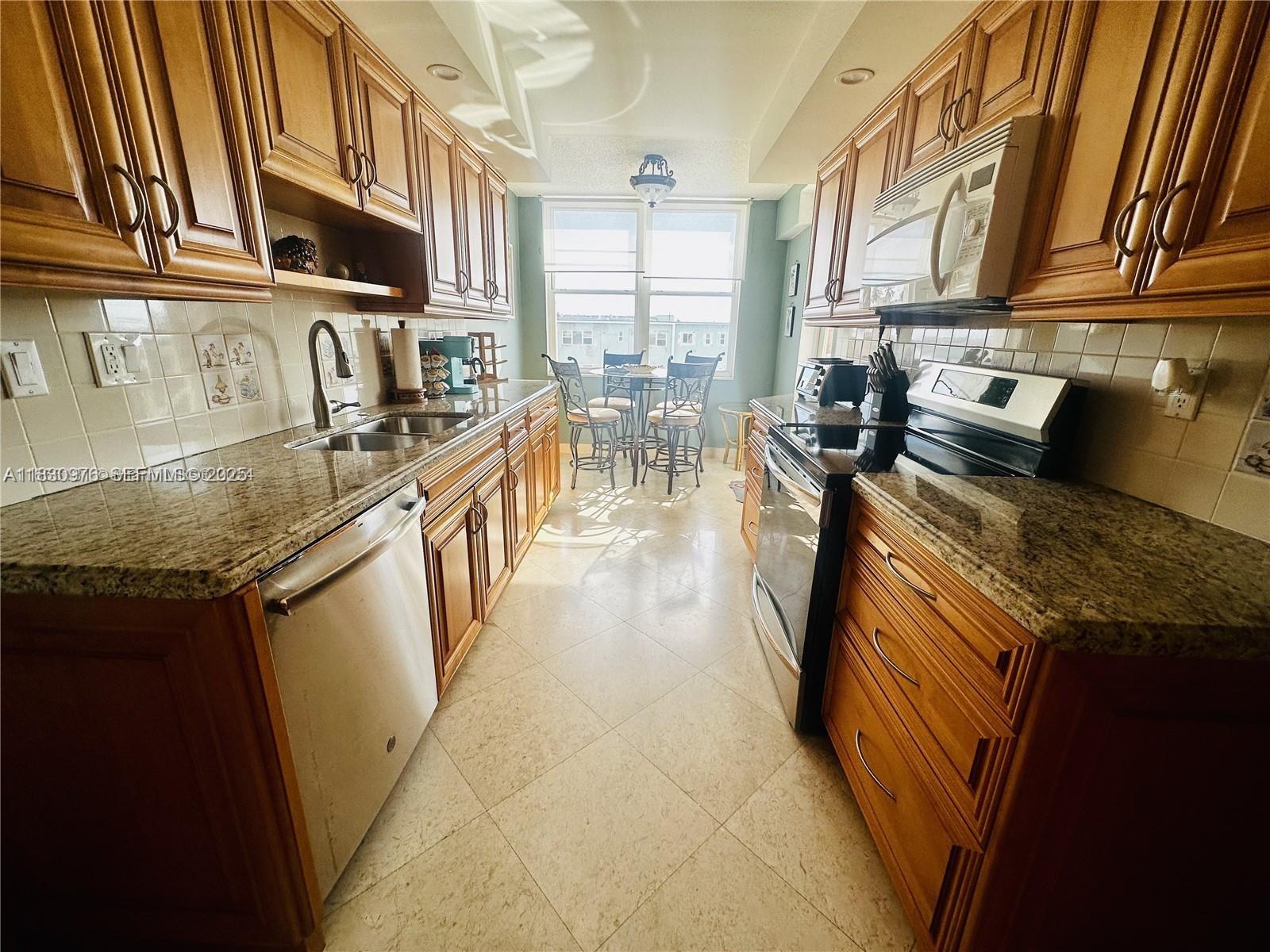 1501 South Ocean Drive, Unit 406 Hollywood, FL 33019 - Photo 6 of 14 a kitchen with stove top oven a sink and dishwasher
