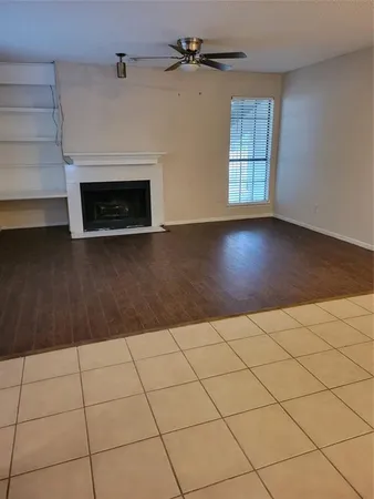 a view of a livingroom with wooden floor and a fireplace