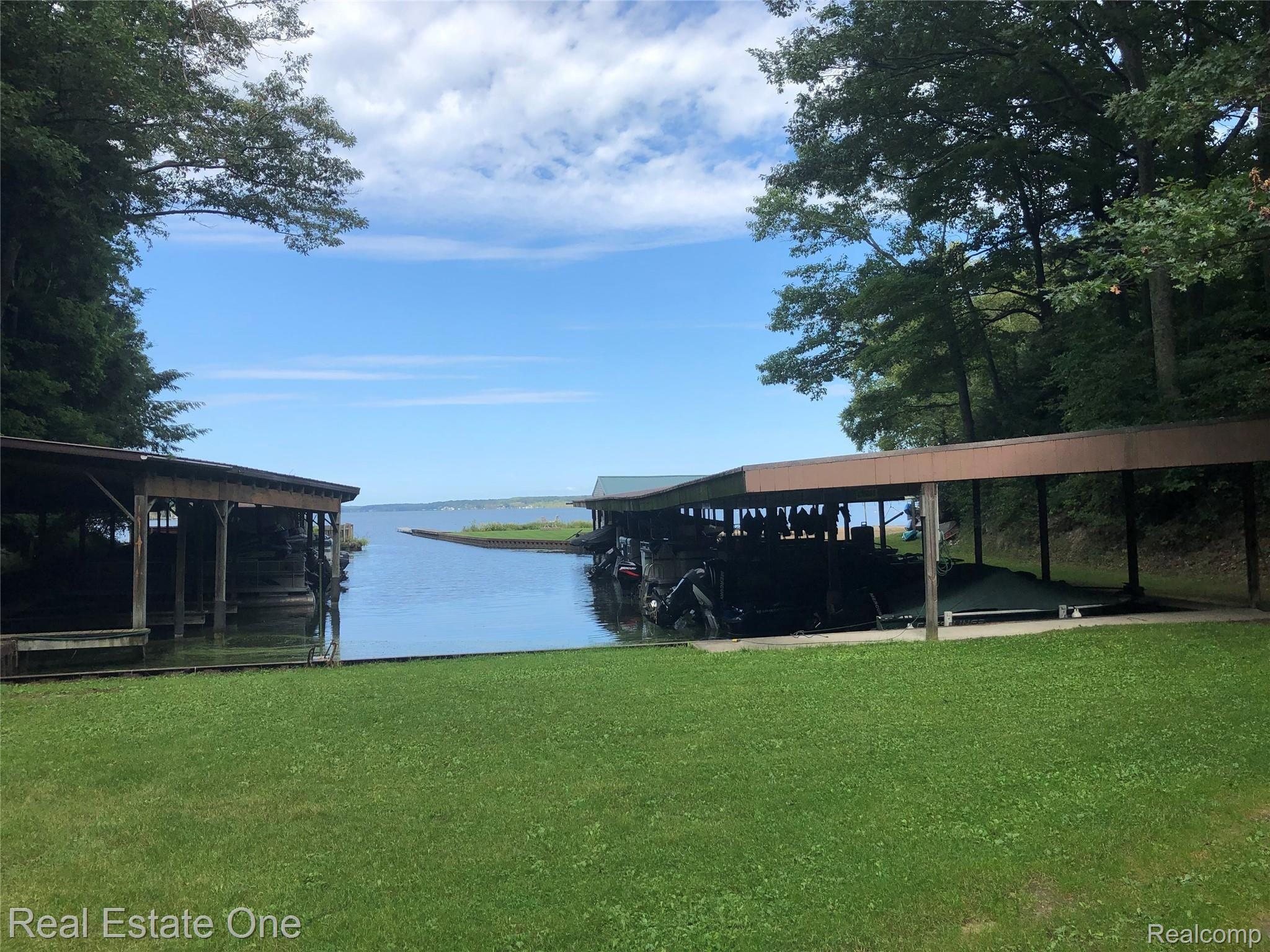 2722 Piney Ridge Road Ludington, MI 49431 - Photo 21 of 64 The Twin Points covered boat slips to the right, dock and beach beyond.