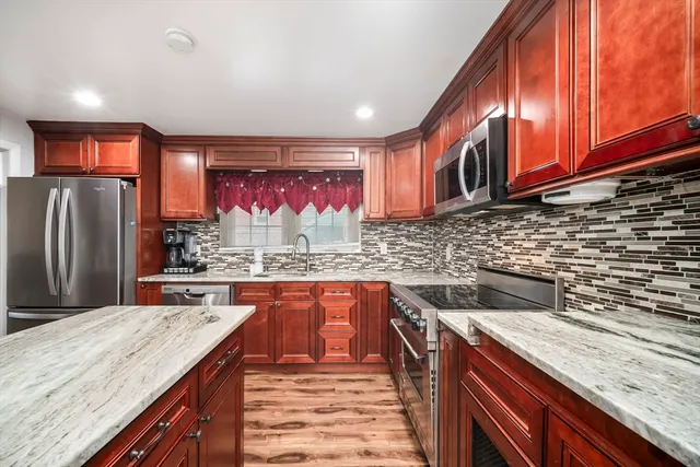 a kitchen with stainless steel appliances granite countertop a sink and wooden cabinets