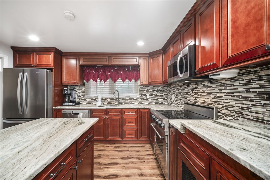 5 Debbie Road Brockton, MA 02302 - Photo 16 of 30 a kitchen with stainless steel appliances granite countertop a sink and wooden cabinets