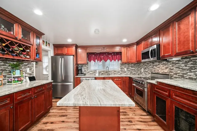 a kitchen with stainless steel appliances granite countertop a refrigerator and a stove top oven