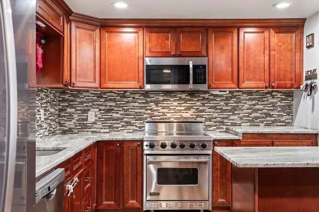 a kitchen with stainless steel appliances granite countertop a stove a sink and a microwave