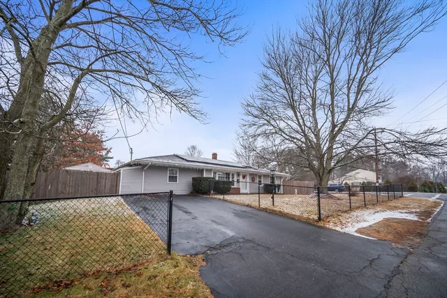 a view of a white house with a large tree