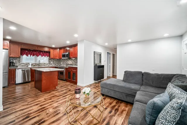 a living room with stainless steel appliances kitchen island granite countertop furniture and a kitchen view