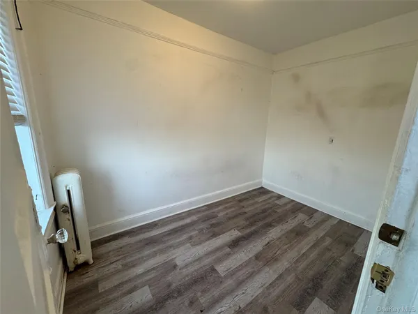 a view of a room with wooden floor and a window