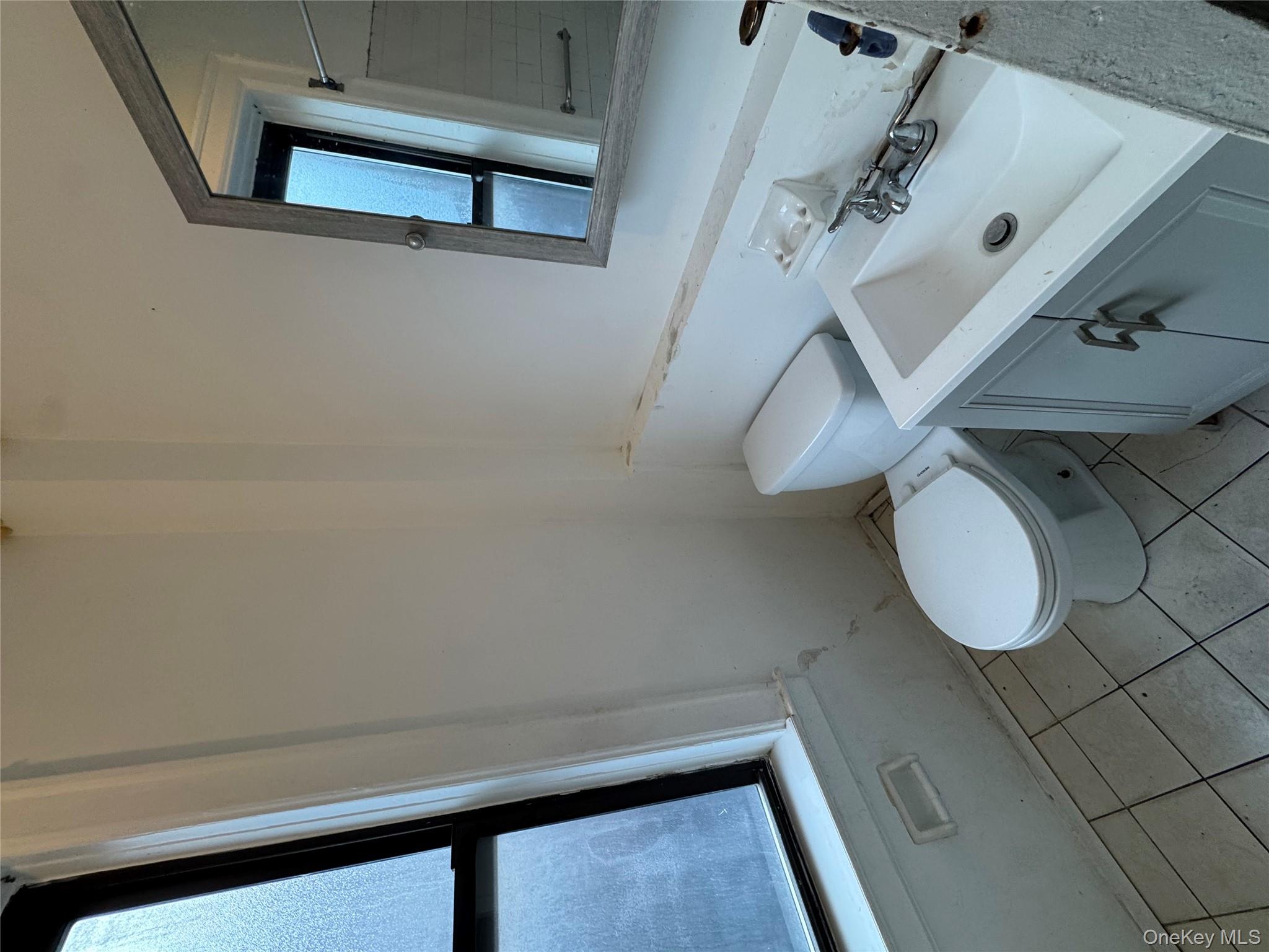 3307 Junction Boulevard, Unit 3 Queens, NY 11372 - Photo 8 of 8 a bathroom with a sink mirror and toilet