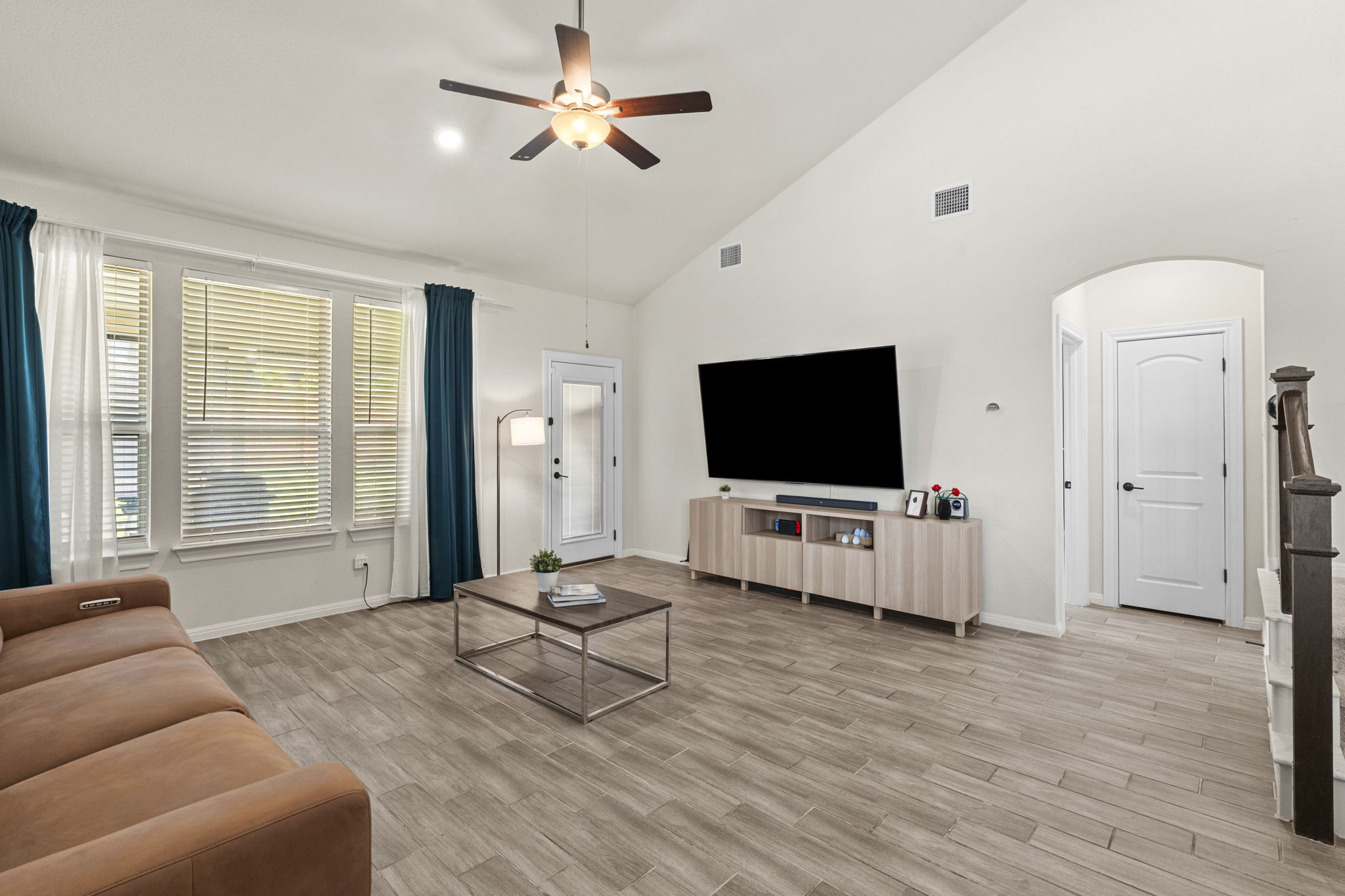548 Purple Heart Drive Buda, TX 78610 - Photo 6 of 35 A living room with vaulted ceilings and abundant natural light from wide windows.