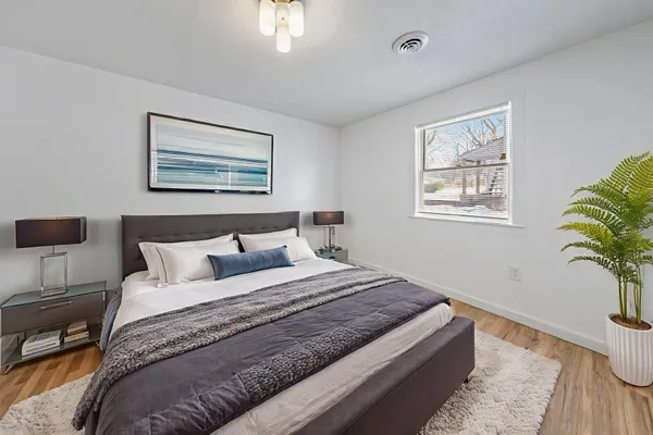 a bedroom with bed plant and window