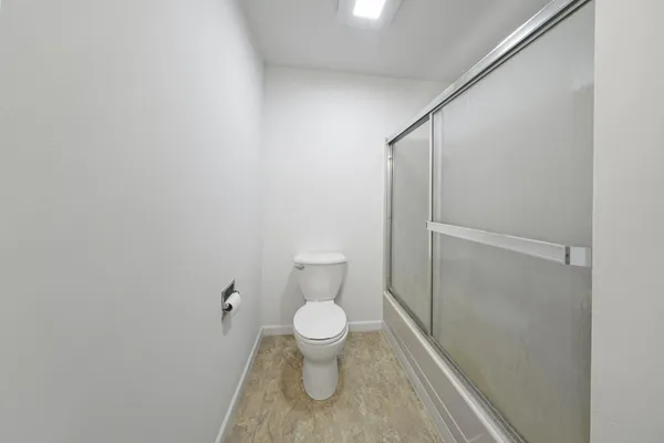 a bathroom with a toilet and a shower