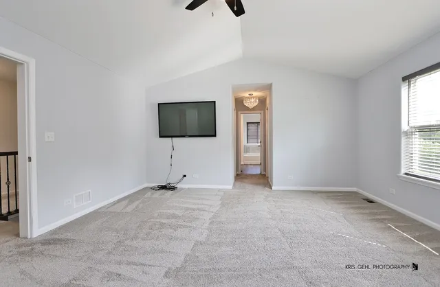an empty room with windows and flat screen tv