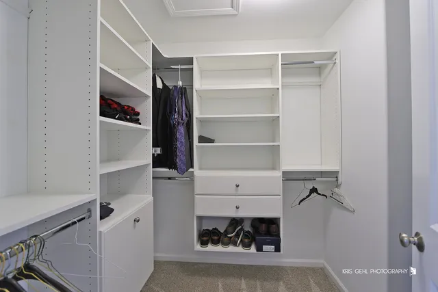 a view of walk in closet with clothes and shoes