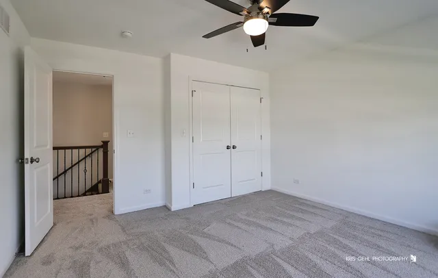 an empty room with closet and a chandelier fan