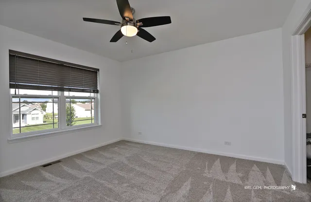 an empty room with a window and a ceiling fan