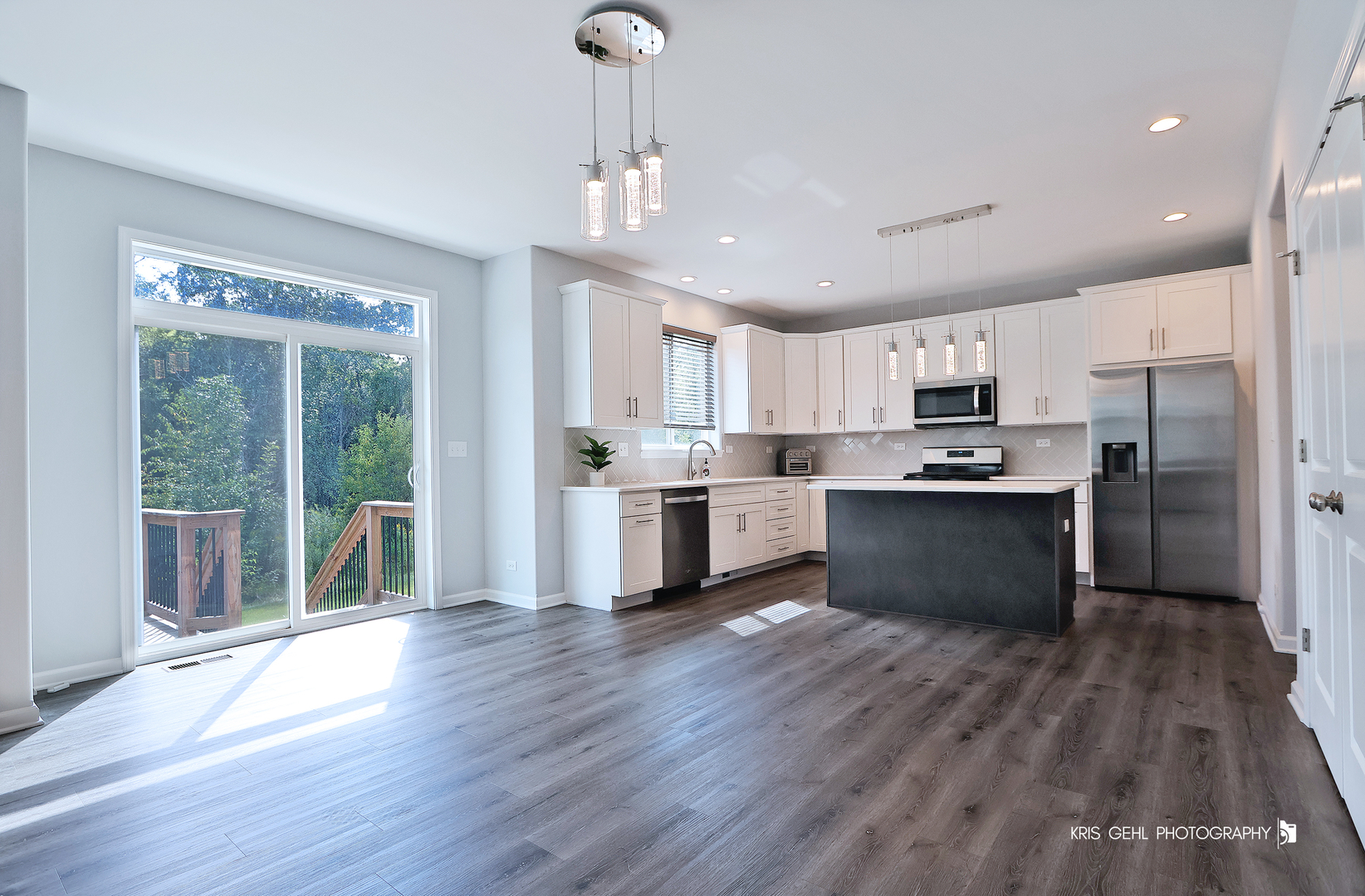 10718 Hunt Club Road Richmond, IL 60071 - Photo 7 of 28 a kitchen with stainless steel appliances kitchen island wooden floors refrigerator and cabinets
