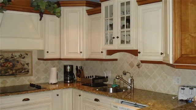 a kitchen with granite countertop white cabinets and stainless steel appliances
