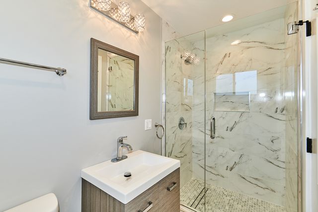 a bathroom with a sink mirror and a shower